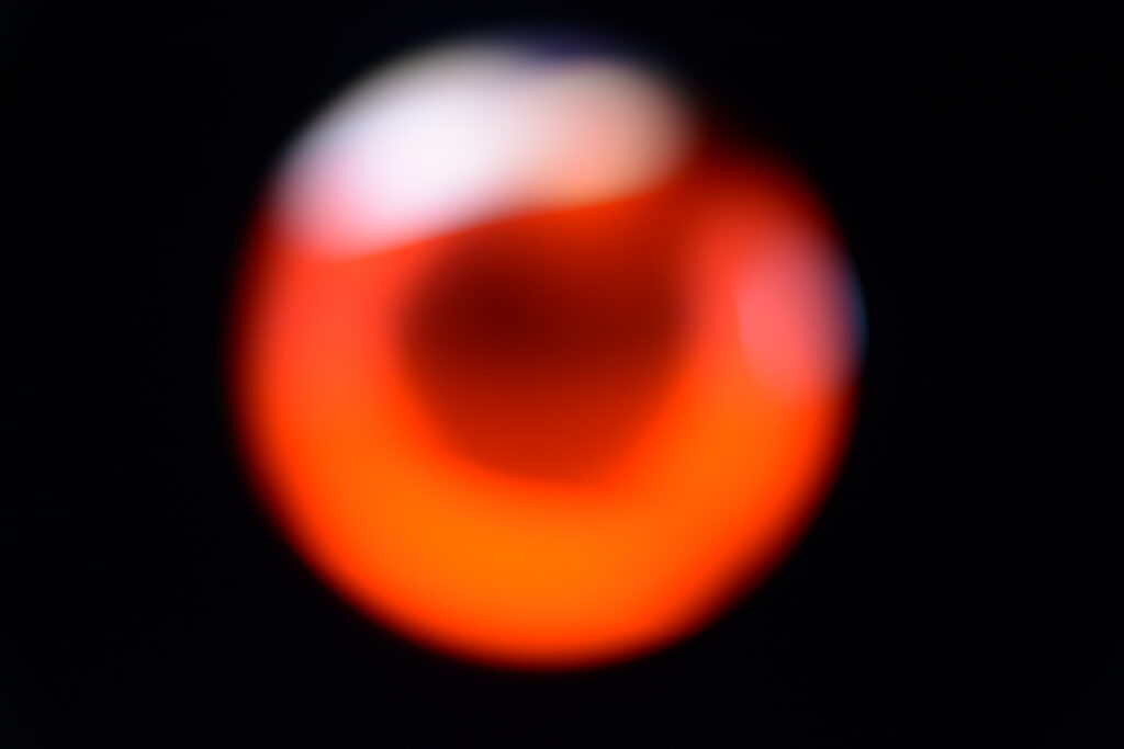The image represents a circular light in red and white.